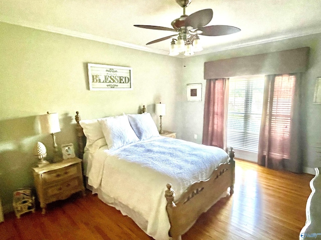 bedroom with ceiling fan, crown molding, and dark hardwood / wood-style flooring