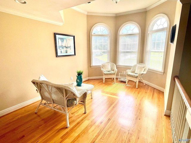 sitting room featuring light wood-type flooring and ornamental molding