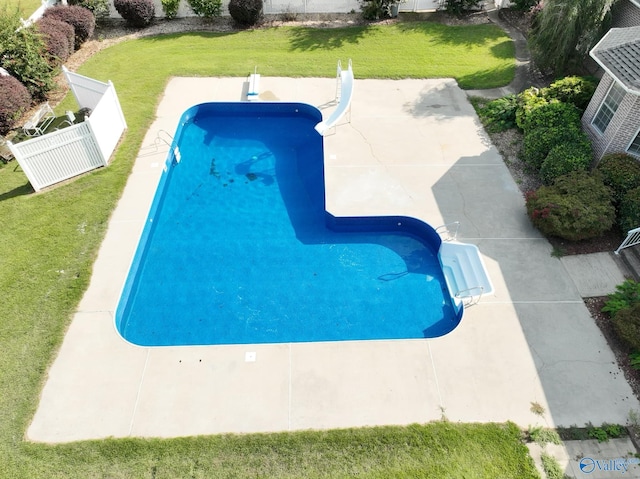 view of pool with a lawn, a water slide, and a patio