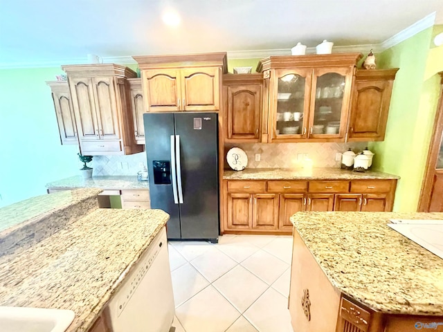 kitchen with refrigerator with ice dispenser, backsplash, and light stone counters