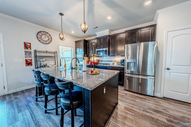 207 Jubilee Cir SE, Huntsville, AL 35803 - kitchen with stainless steel appliances, ornamental molding, a breakfast bar area, light stone countertops, and wood finished floors