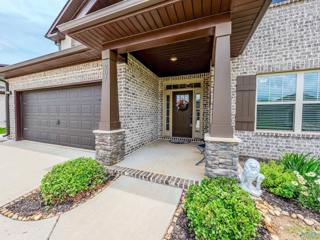 207 Jubilee Cir SE, Huntsville, AL 35803 - doorway to property featuring brick siding, an attached garage, covered porch, and concrete driveway