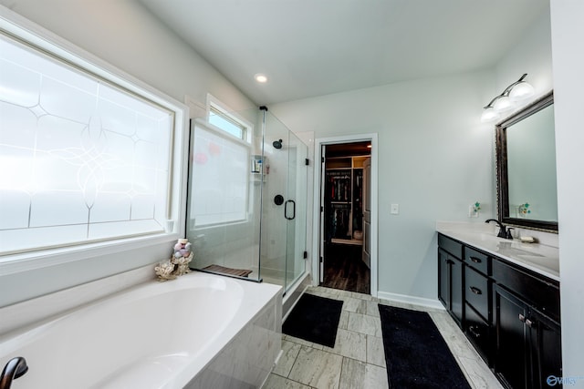 207 Jubilee Cir SE, Huntsville, AL 35803 - bathroom with double vanity, a stall shower, a garden tub, a walk in closet, and recessed lighting