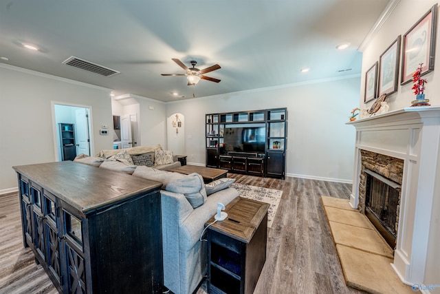 207 Jubilee Cir SE, Huntsville, AL 35803 - living room featuring light wood-type flooring, a stone fireplace, crown molding, ceiling fan, and recessed lighting