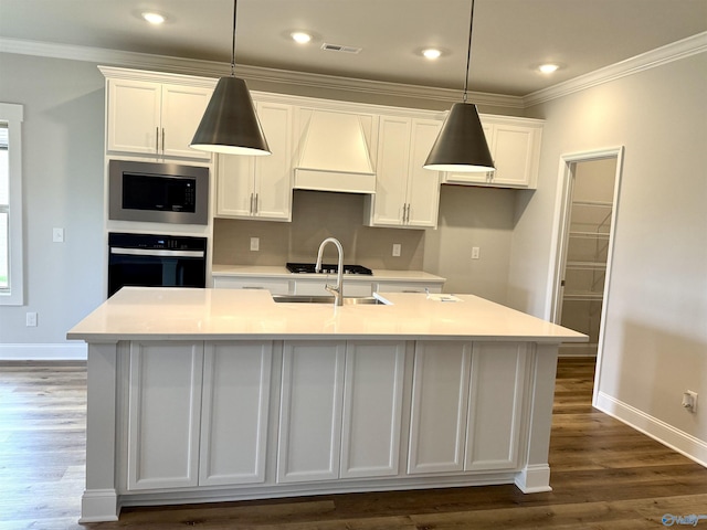 121 Headen Ln, Huntsville, AL 35811 - kitchen with black oven, stainless steel microwave, white cabinets, custom exhaust hood, and an island with sink