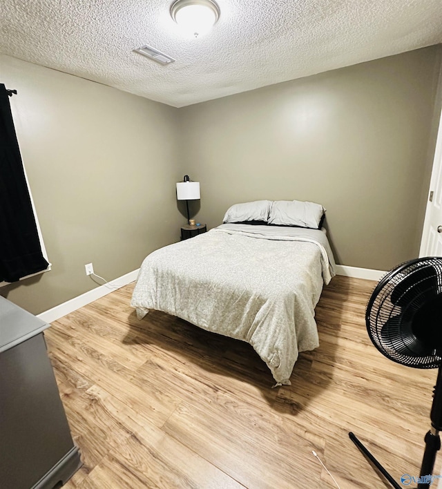 26 Prospect St, Town Creek, AL 35672 - bedroom featuring light wood finished floors, baseboards, visible vents, and a textured ceiling