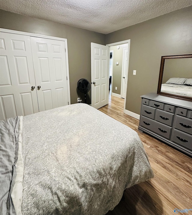 26 Prospect St, Town Creek, AL 35672 - bedroom with light wood-type flooring, a textured ceiling, and a closet