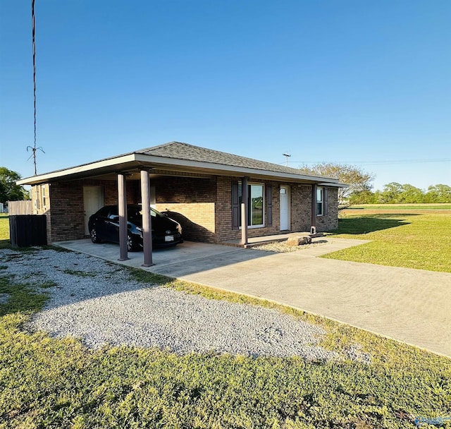26 Prospect St, Town Creek, AL 35672 - ranch-style home featuring a carport, driveway, brick siding, and a front yard