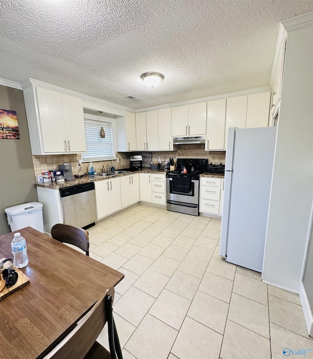 26 Prospect St, Town Creek, AL 35672 - kitchen featuring under cabinet range hood, backsplash, appliances with stainless steel finishes, and ornamental molding