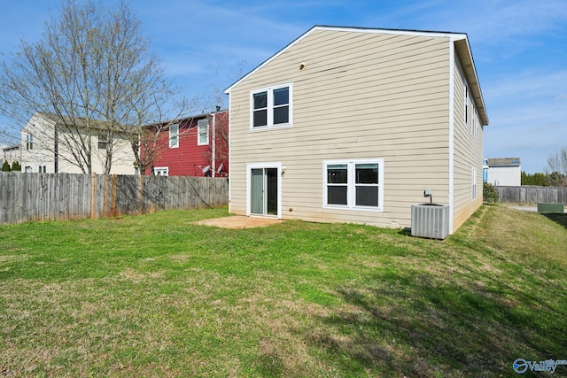 rear view of property with central AC and a lawn