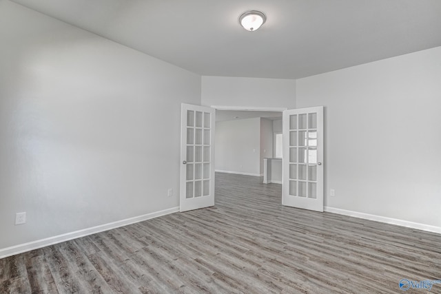 empty room with french doors, wood finished floors, and baseboards