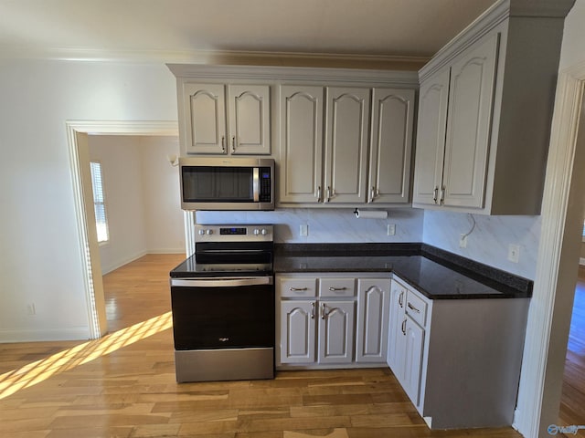 kitchen with gray cabinets, stainless steel appliances, and light wood-type flooring