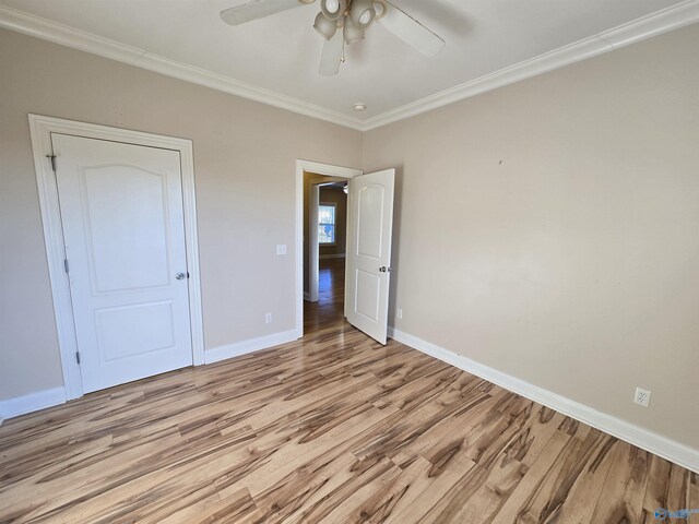 unfurnished bedroom featuring crown molding, ceiling fan, and light wood-type flooring