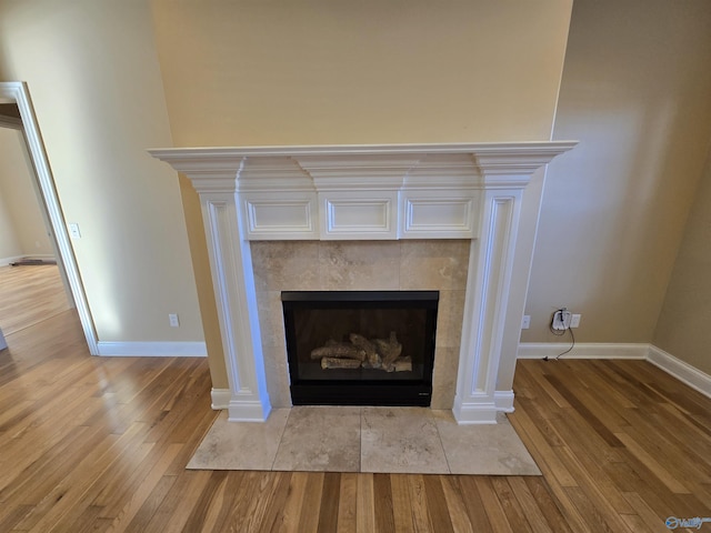 interior details featuring wood-type flooring and a tile fireplace