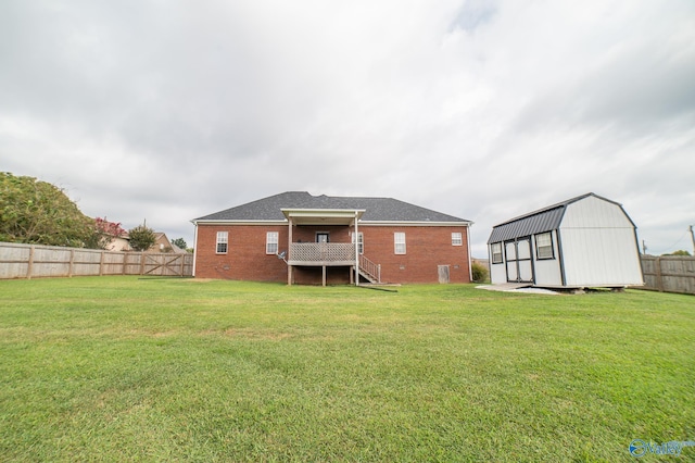 rear view of house featuring a storage shed and a yard