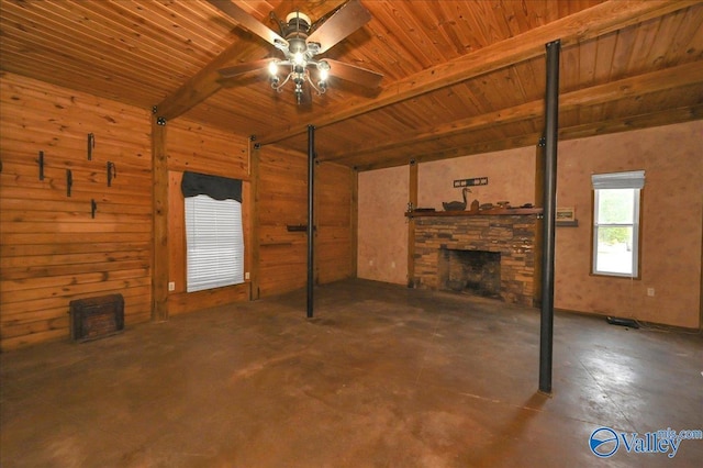 83 James Rd, Hartselle, AL 35640 - unfurnished living room with a wooden ceiling with exposed beams, concrete floors, ceiling fan, a fireplace, and wood walls