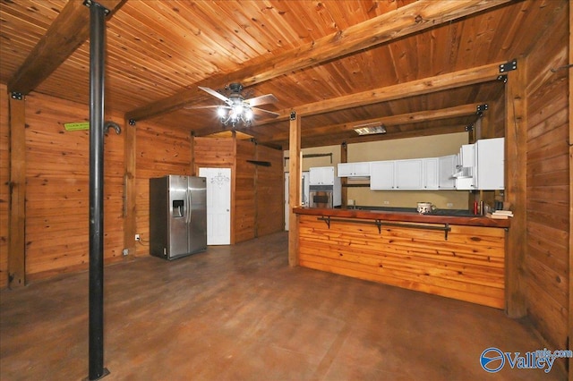 83 James Rd, Hartselle, AL 35640 - kitchen featuring stainless steel refrigerator with ice dispenser, wood walls, a ceiling fan, concrete flooring, and a wood ceiling with exposed beams