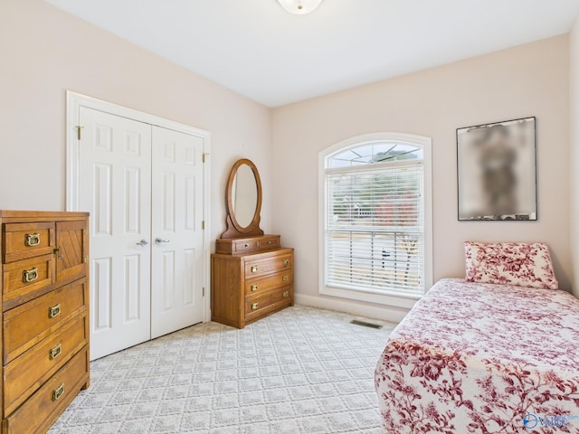 bedroom featuring a closet, visible vents, and light colored carpet