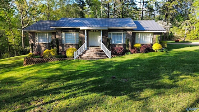 single story home featuring a front lawn, brick siding, and metal roof