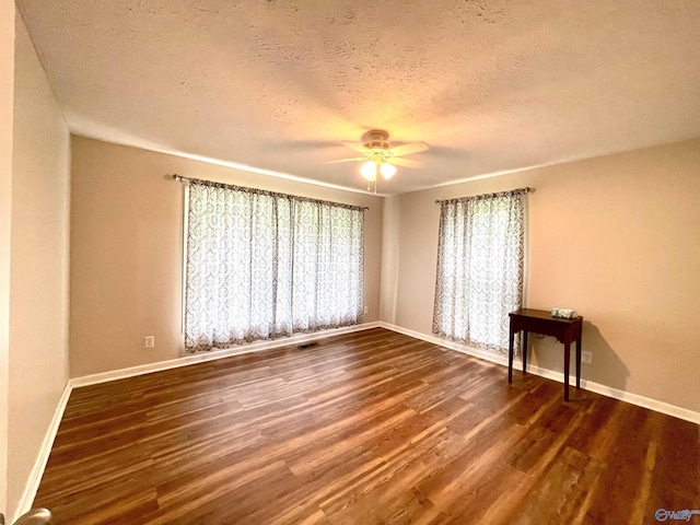 spare room featuring a textured ceiling, baseboards, a ceiling fan, and wood finished floors