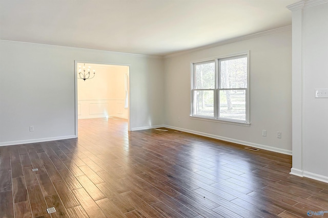 unfurnished room featuring ornamental molding, dark wood-type flooring, and an inviting chandelier