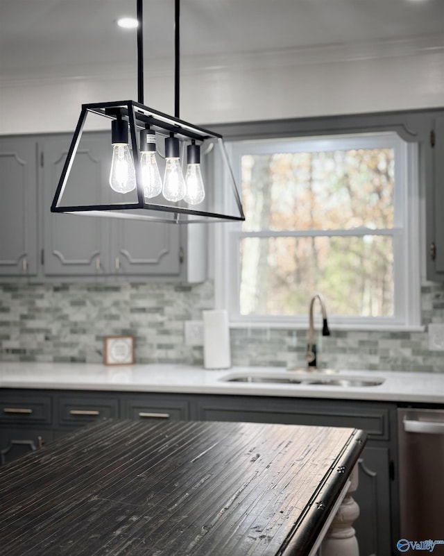 kitchen with dishwasher, ornamental molding, gray cabinetry, and sink