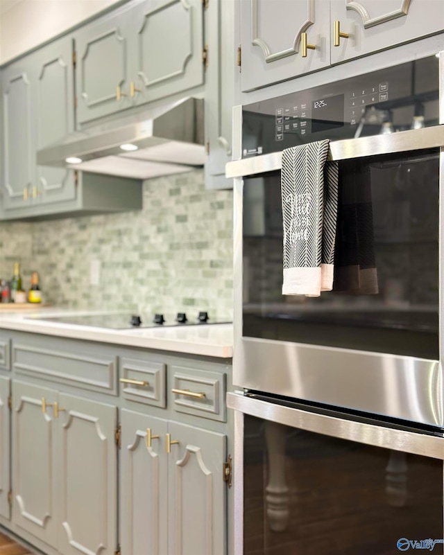 kitchen with double oven, backsplash, and stovetop