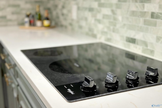 details with black electric cooktop and tasteful backsplash