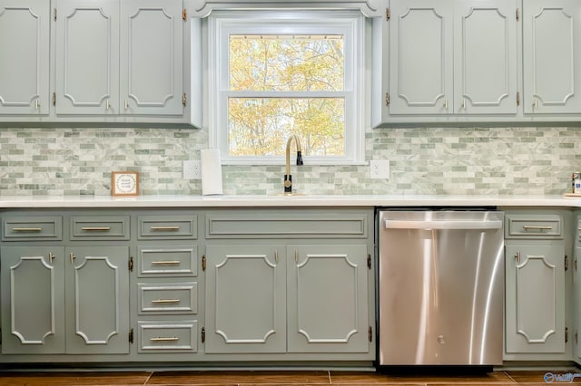 kitchen with dishwasher, dark hardwood / wood-style flooring, sink, and tasteful backsplash