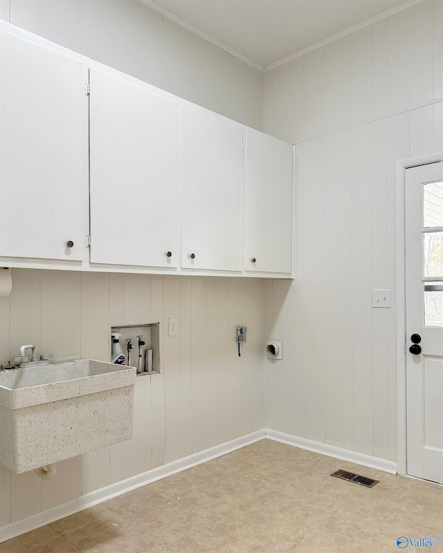 washroom with cabinets, crown molding, and hookup for a washing machine