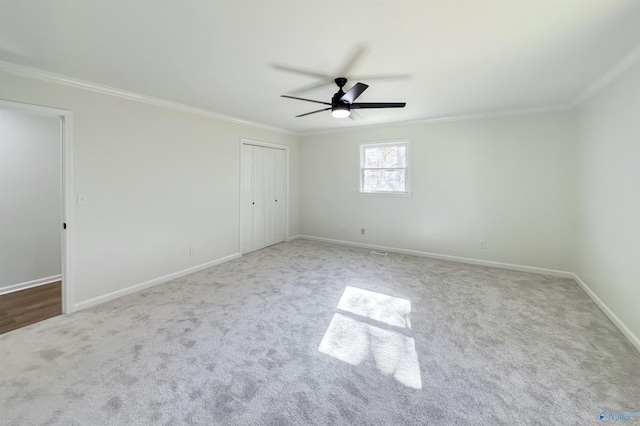 carpeted empty room featuring ceiling fan and ornamental molding