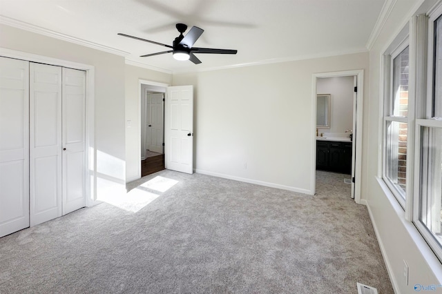 unfurnished bedroom with light carpet, ensuite bathroom, ceiling fan, ornamental molding, and a closet