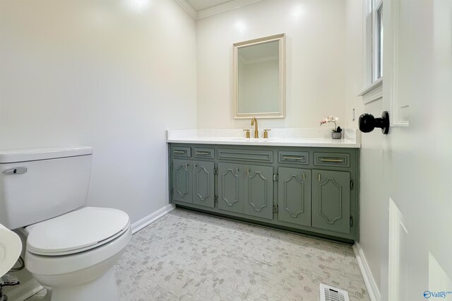 bathroom with vanity, toilet, and ornamental molding