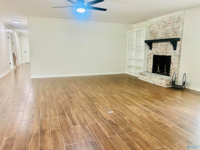 unfurnished living room featuring wood-type flooring, a brick fireplace, and crown molding