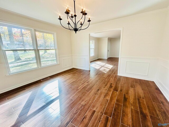 unfurnished dining area with crown molding, dark wood-type flooring, and a notable chandelier