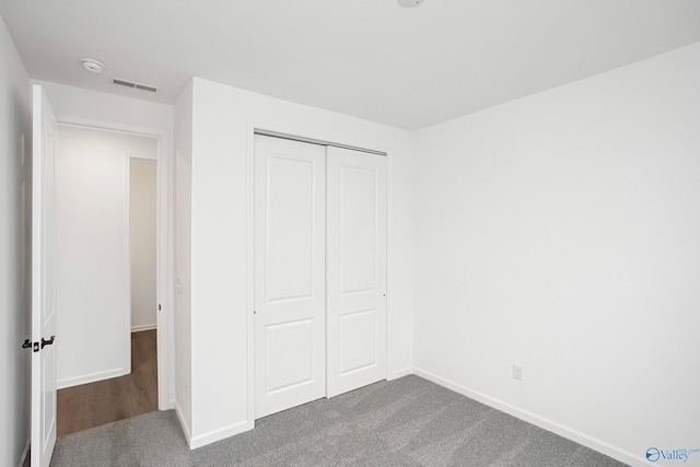 unfurnished bedroom with a closet and carpet flooring