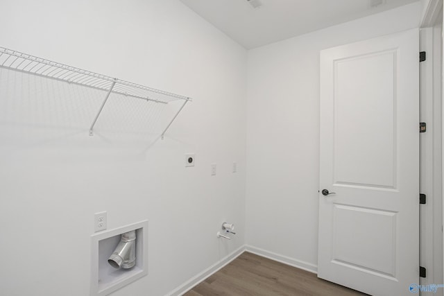 clothes washing area featuring gas dryer hookup, hardwood / wood-style flooring, and hookup for an electric dryer