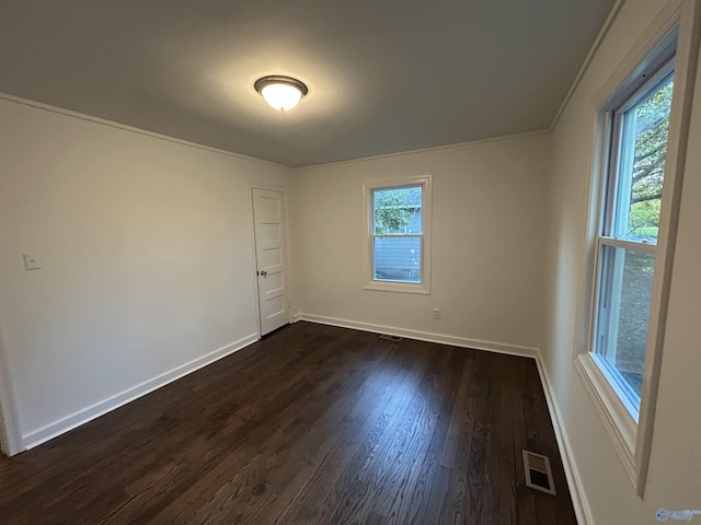 empty room featuring dark hardwood / wood-style flooring and crown molding