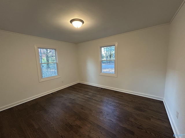 spare room with dark wood-type flooring and ornamental molding