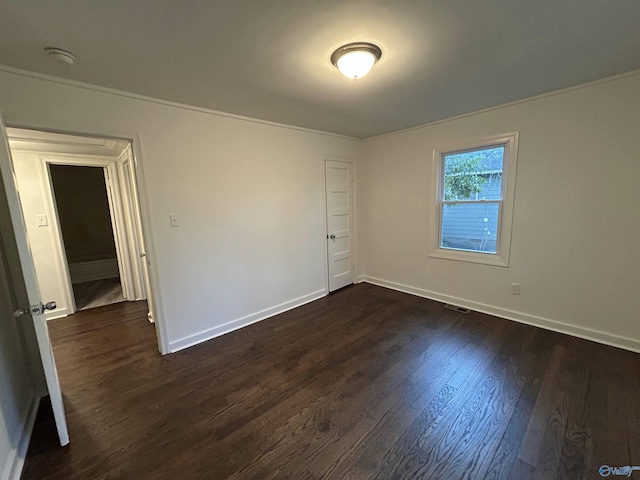 unfurnished room with crown molding and dark wood-type flooring