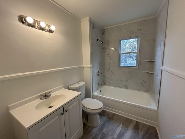 full bathroom with ornamental molding, vanity, wood-type flooring, toilet, and tiled shower / bath