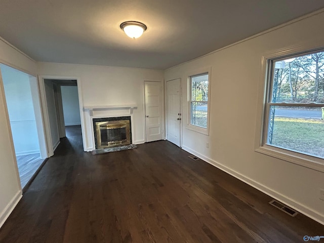 unfurnished living room with a high end fireplace and dark wood-type flooring