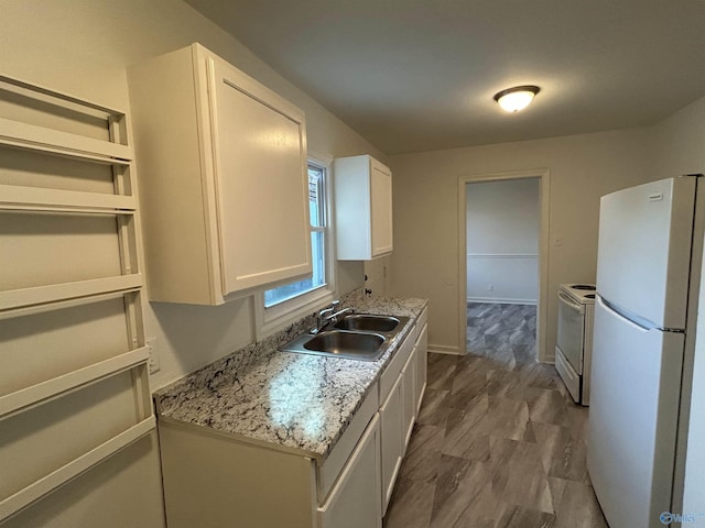 kitchen featuring white cabinets, white appliances, light stone countertops, and sink