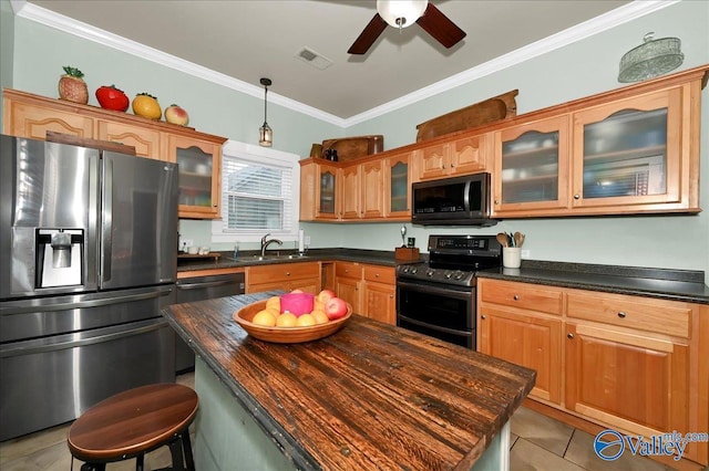kitchen featuring a kitchen island, sink, stainless steel appliances, ornamental molding, and light tile patterned floors