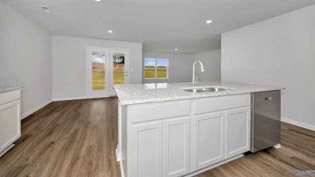 kitchen featuring dishwasher, sink, white cabinets, and an island with sink