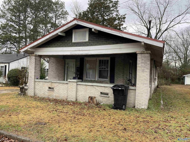 bungalow featuring a front lawn and covered porch