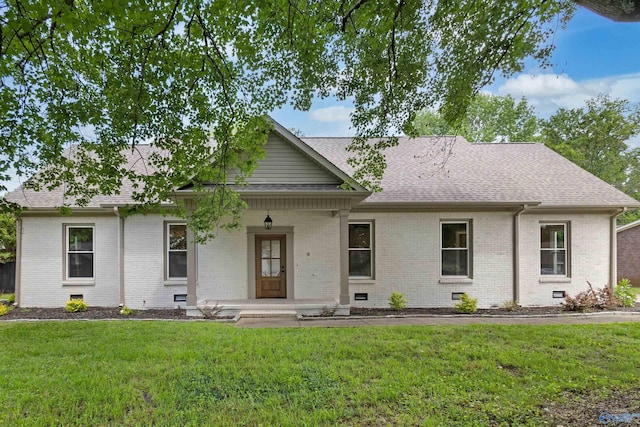 view of front of house with covered porch, brick siding, a shingled roof, a front yard, and crawl space