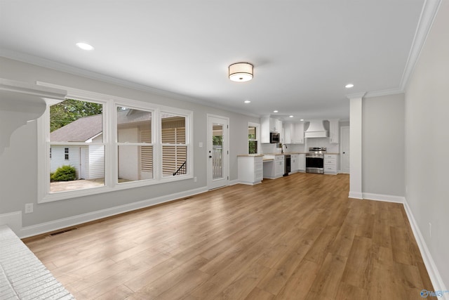 unfurnished living room featuring ornamental molding, baseboards, light wood finished floors, and recessed lighting