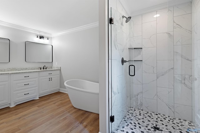 bathroom featuring crown molding, a stall shower, double vanity, and a freestanding bath