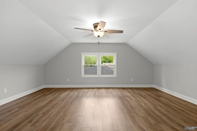 additional living space with a ceiling fan, wood finished floors, vaulted ceiling, and baseboards